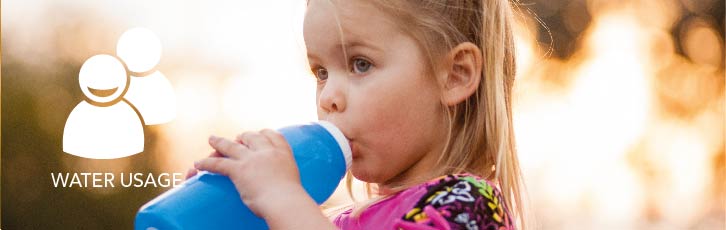 A young girl drinks from a bottle